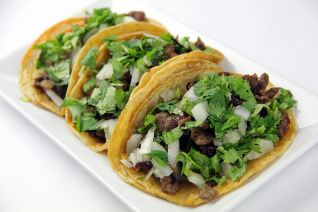 Mouth-watering beef tacos topped with fresh cilantro and onions.