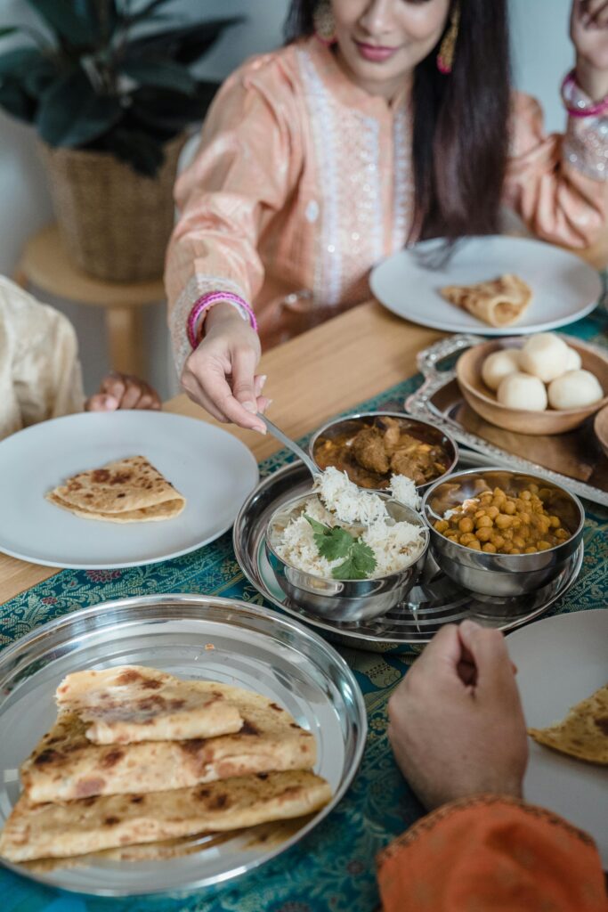 Enjoying Indian cuisine together with family at home, sharing naan, curry, and rice.